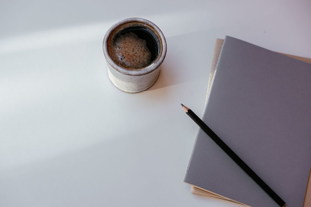 Caderno aberto com xícara de café